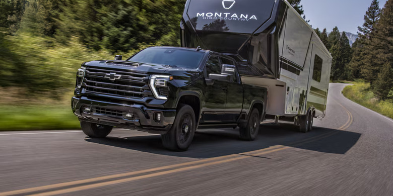 Chevy Silverado HD towing a fifth wheel trailer on the road