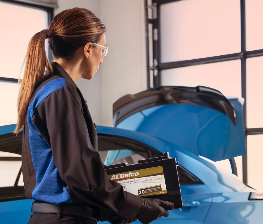 Cadillac certified mechanic replacing the battery in a Cadillac vehicle in a shop near Gilbert, AZ