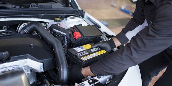 Cadillac certified technician installing a new battery in Tempe, AZ