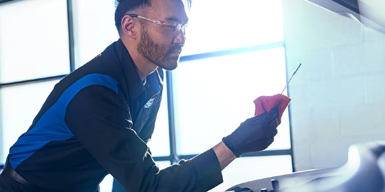 Certified Cadillac Master technician checking the oil in a vehicle at Coulter Cadillac in Phoenix