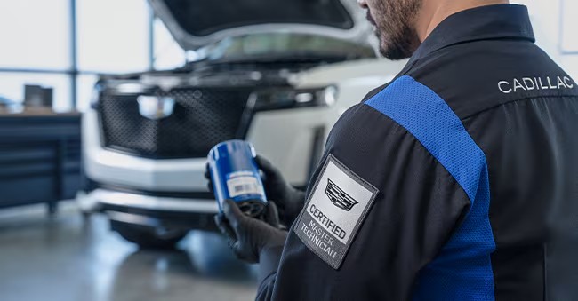 Certified Cadillac Master technician replacing the oil filter in a vehicle at Coulter Cadillac in Phoenix