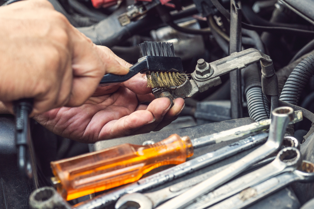 Technician Cleaning a Corroded Battery Terminal
