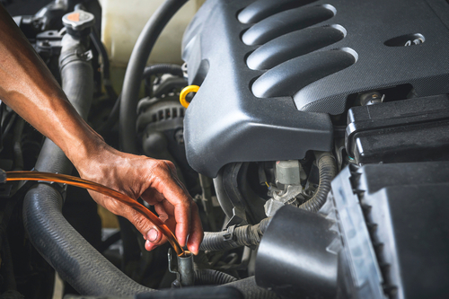 Auto mechanic Filling The New CVT Transmission Fluid in Automatic Transmission Fill Hole.