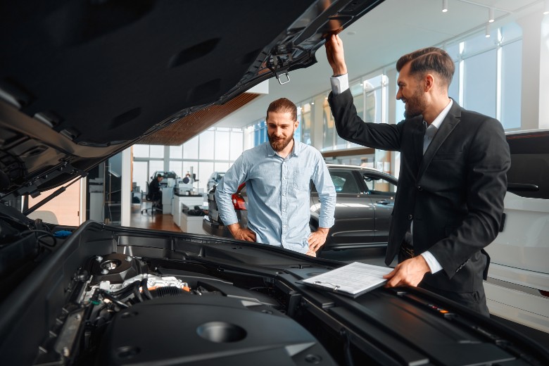 Checking under the hood of a used car near Carrollton GA