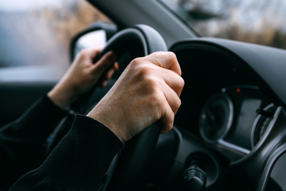 image showing two hands on a steering wheel