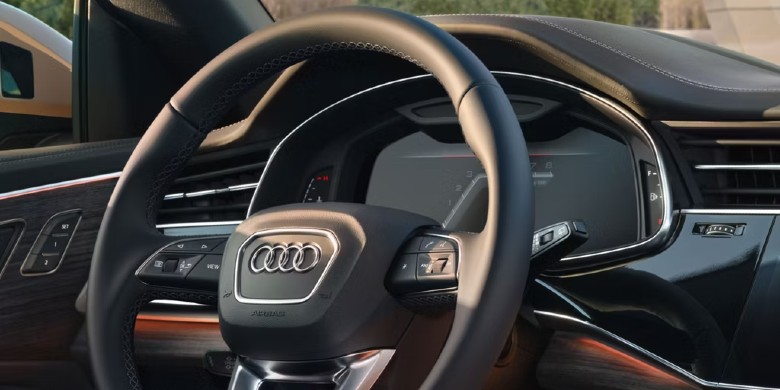 Interior view of the steering wheel, dashboard, and infotainment system in the 2025 Audi Q8 e-tron for sale in Racine, WI