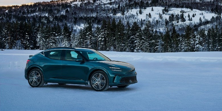 Front exterior view of a 2026 Genesis GV60 using snow mode to drive over snow in Wisconsin
