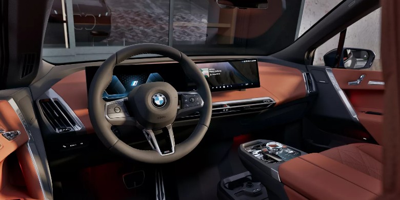 Interior view of the steering wheel, dashboard, and infotainment system in the 2026 BMW iX