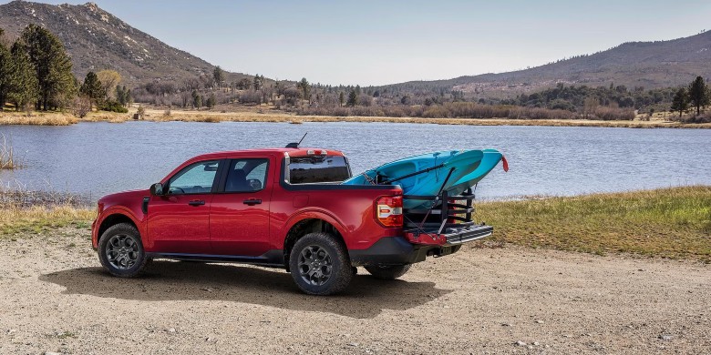 2026 Ford Maverick towing a kayak trailer near a lake
