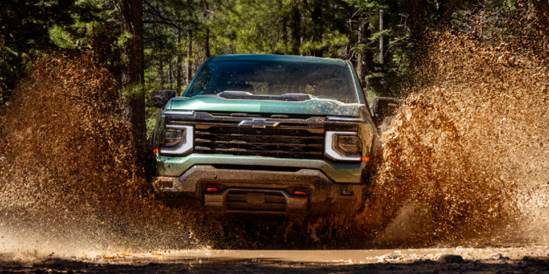 2027 Chevrolet Silverado 1500 Trail Boss driving through mud