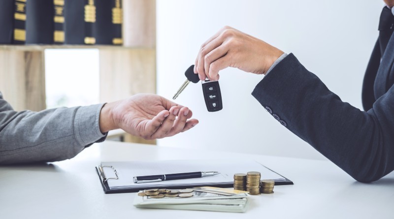 New driver being handed keys after buying a new car