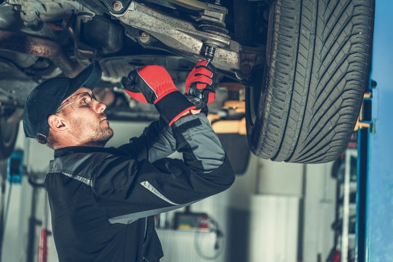 Service mechanic adjusting the tension of a car suspension