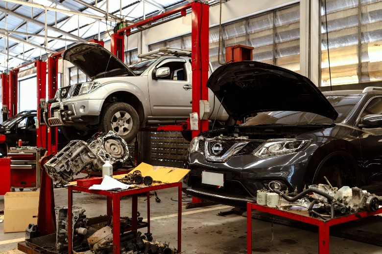Technician performing maintenance under the hood of a vehicle