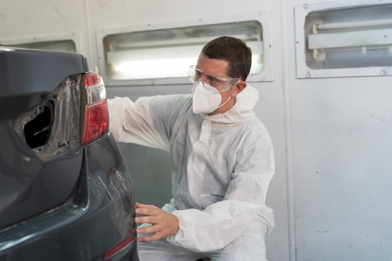 Technician finishing paint repair on a vehicle at Olson Chevrolet