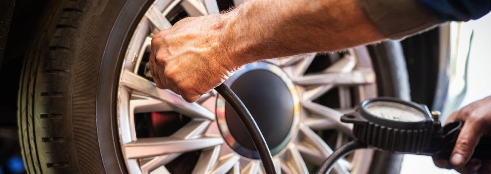 Hyundai Lake Country service technician checking tire pressure with a gauge in Oconomowoc, WI