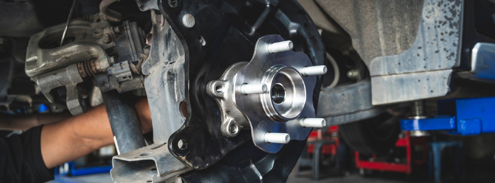 Technician inspecting a wheel hub and wheel bearing at Frank Boucher Kia of Racine