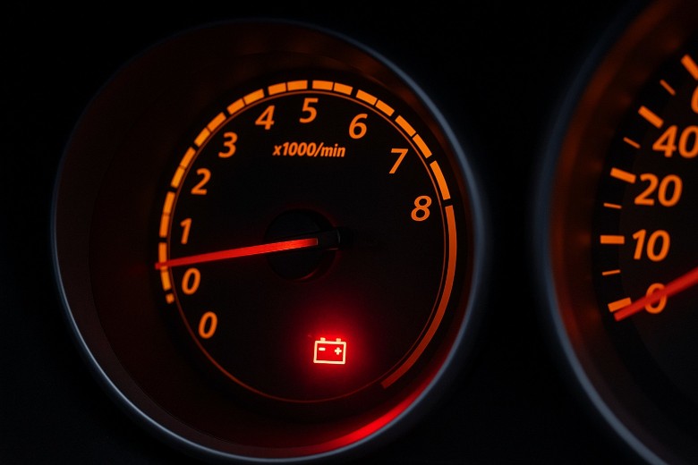 View of a dashboard with a service light on in the shape of a car battery