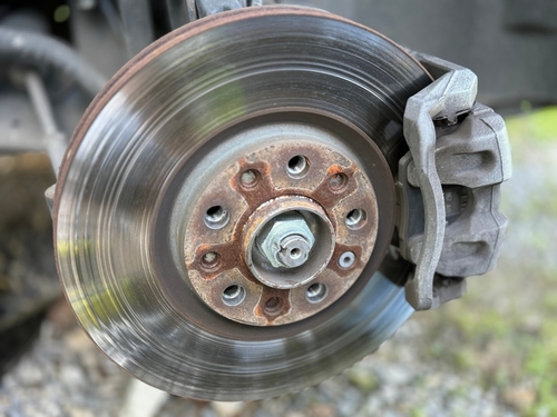 Close-up of a warped brake rotor showing uneven wear grooves