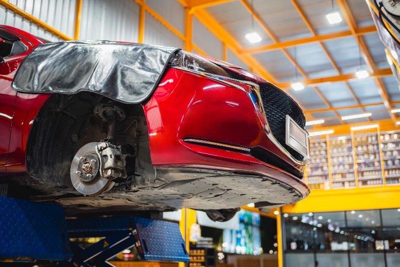 Vehicle on a lift for OEM parts collision repair at Olson Chevrolet