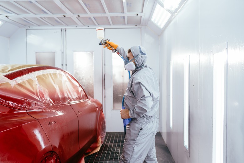 Technician repainting a vehicle in the paint booth at Olson Chevrolet