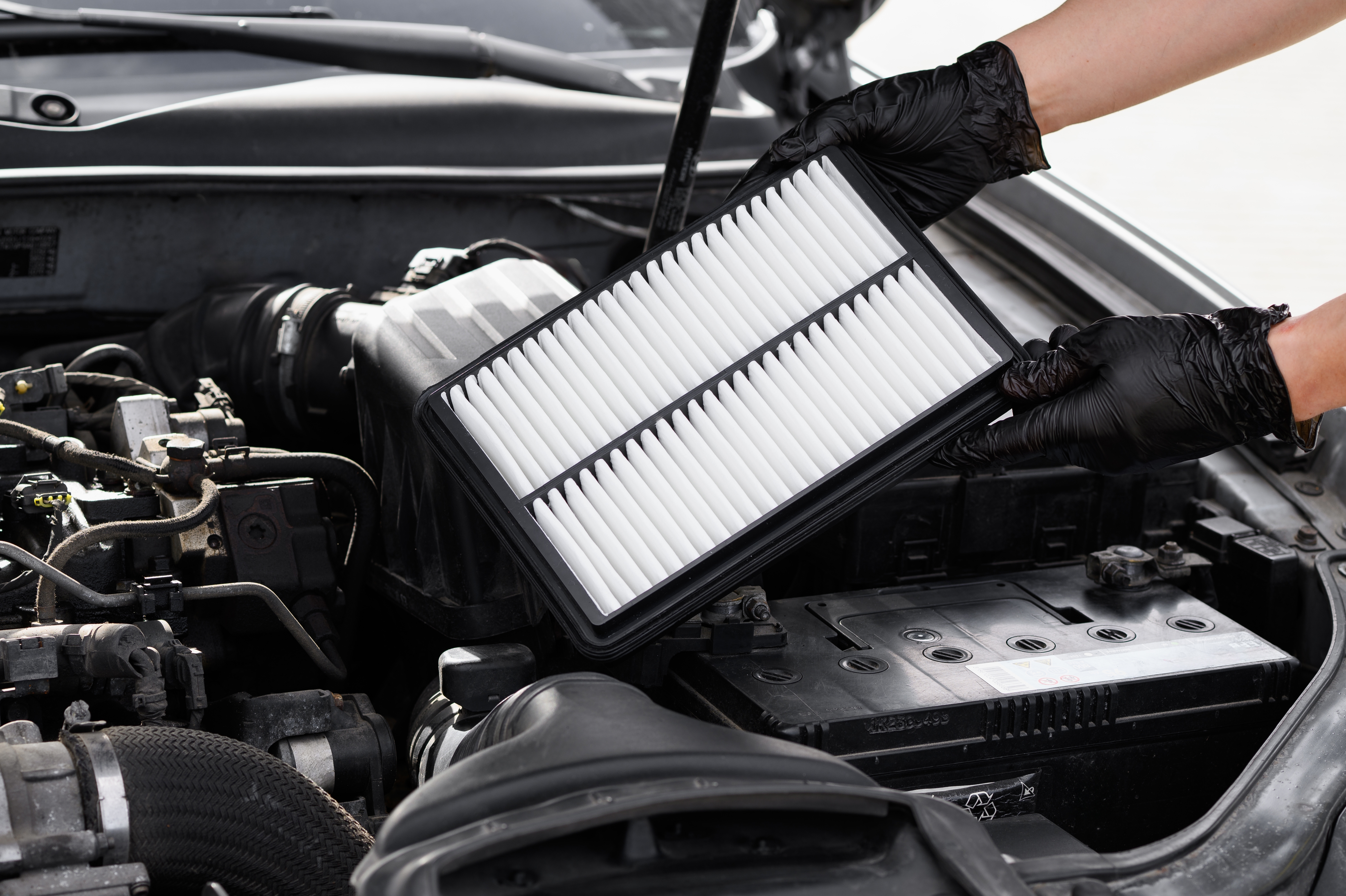 mechanic in Phoenix, AZ replacing the air filter in a car