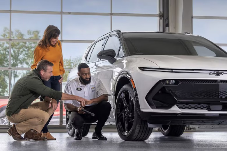 A Chevrolet technician checking tire tread with a customer