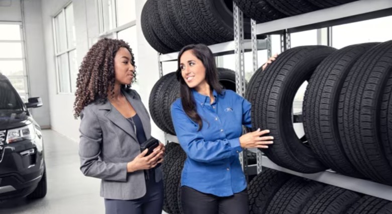 Ford mechanic showing client tires in Santa Fe, NM