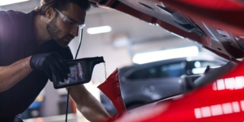 Art Hill Mazda Technician Adding Oil