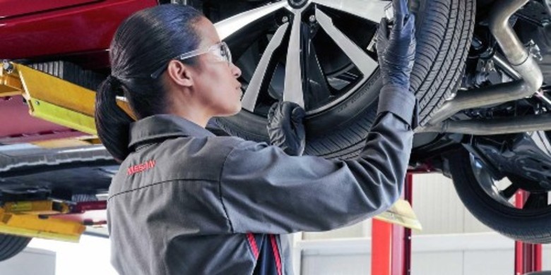 A Nissan certified service technician performing tire services and inspections near West Bend, WI
