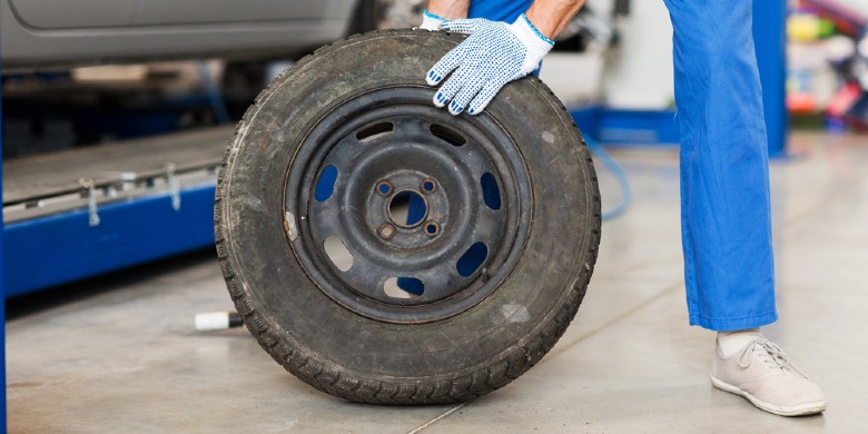 mechanic replacing old tire