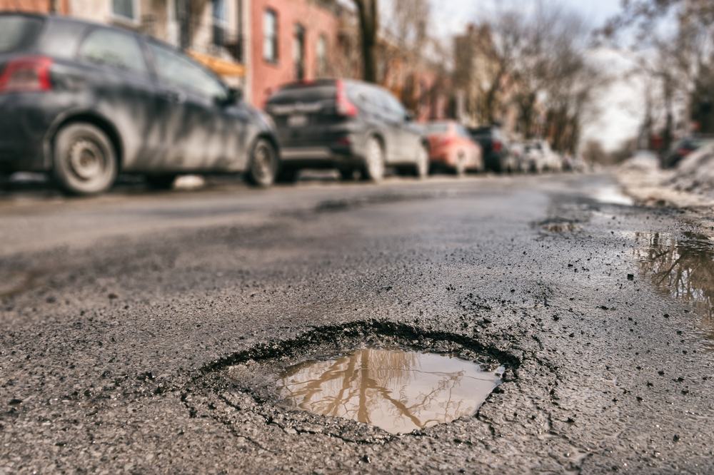 Pothole with Cars in the Back