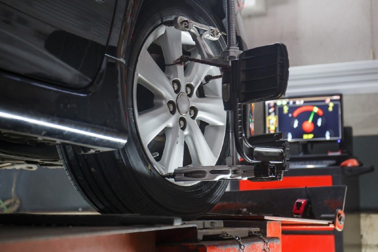 Technician performing wheel alignment | Keweenaw Chevrolet Houghton MI