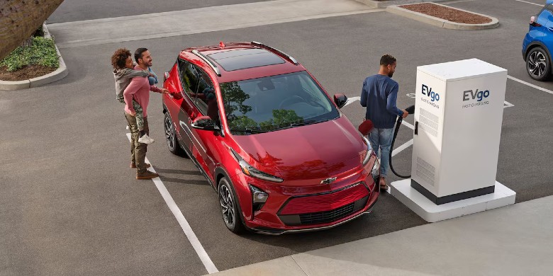 View of an EV driver plugging in their EV to their home charger