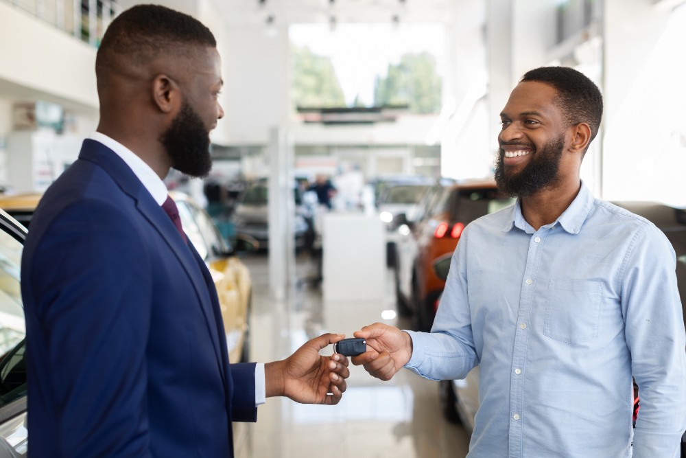 A happy couple holding the keys of their used vehicle they purchased