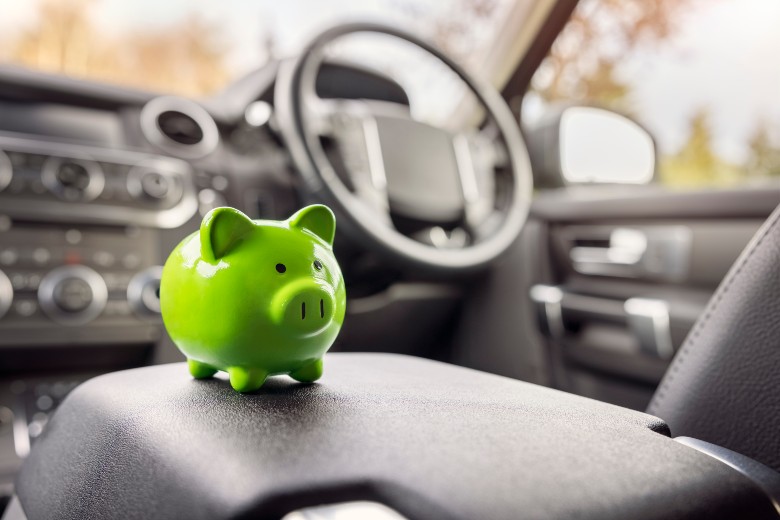 Green piggy bank sitting on a car's center console