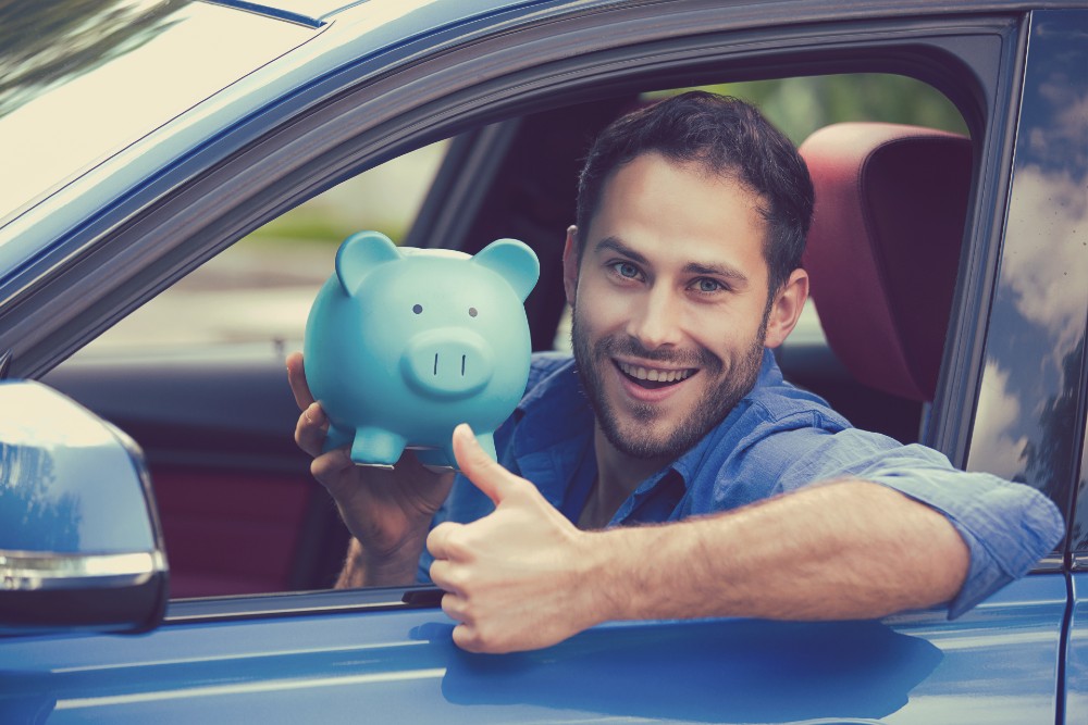Driver with piggy bank representing financing options at Shore Motor Company